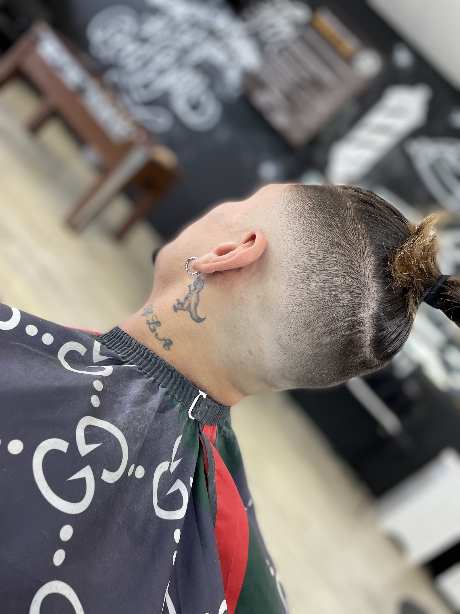Overhead angle of a client with a high fade and small ponytail