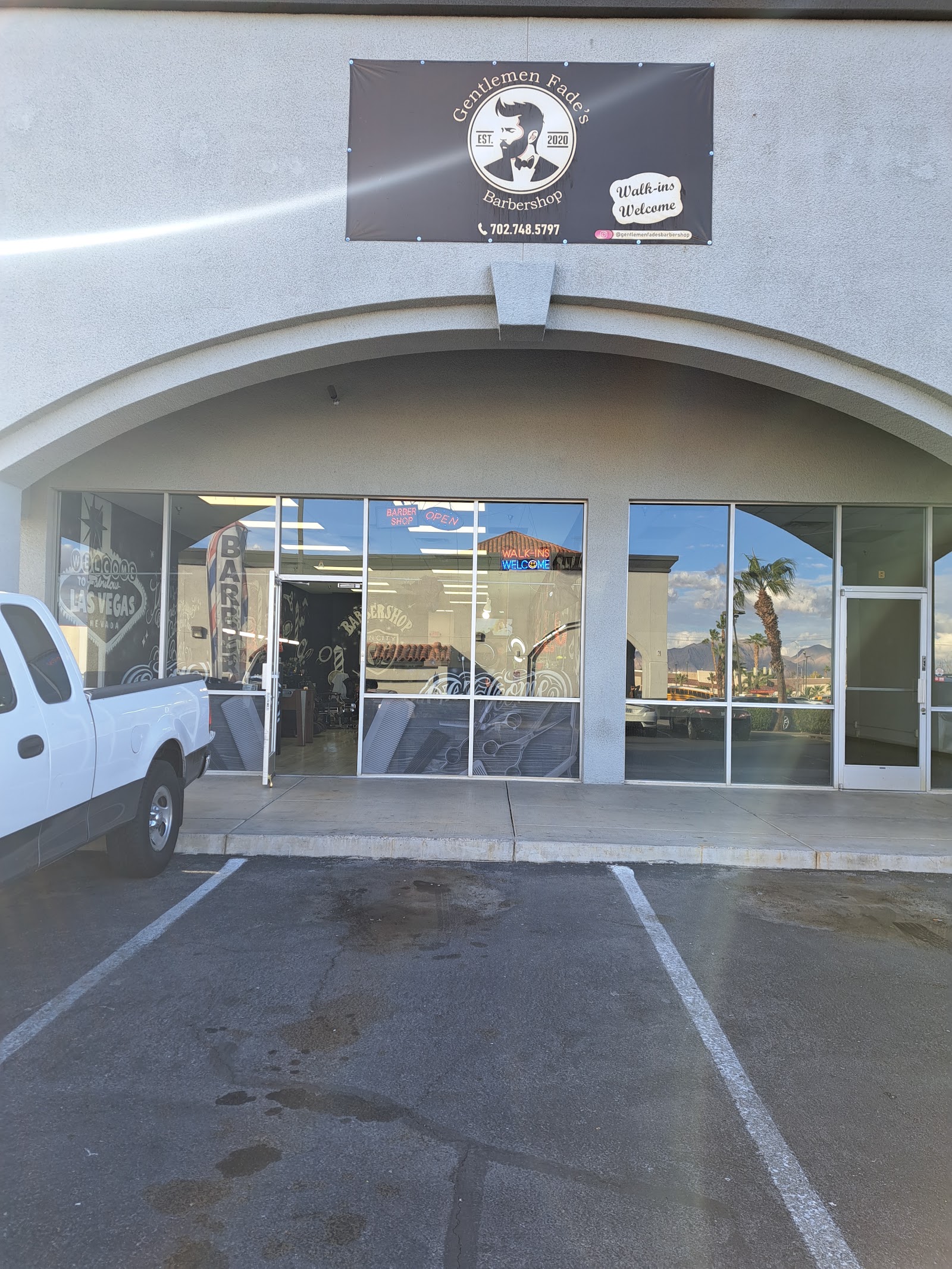 Exterior of the barbershop with signage and a walk-ins welcome banner