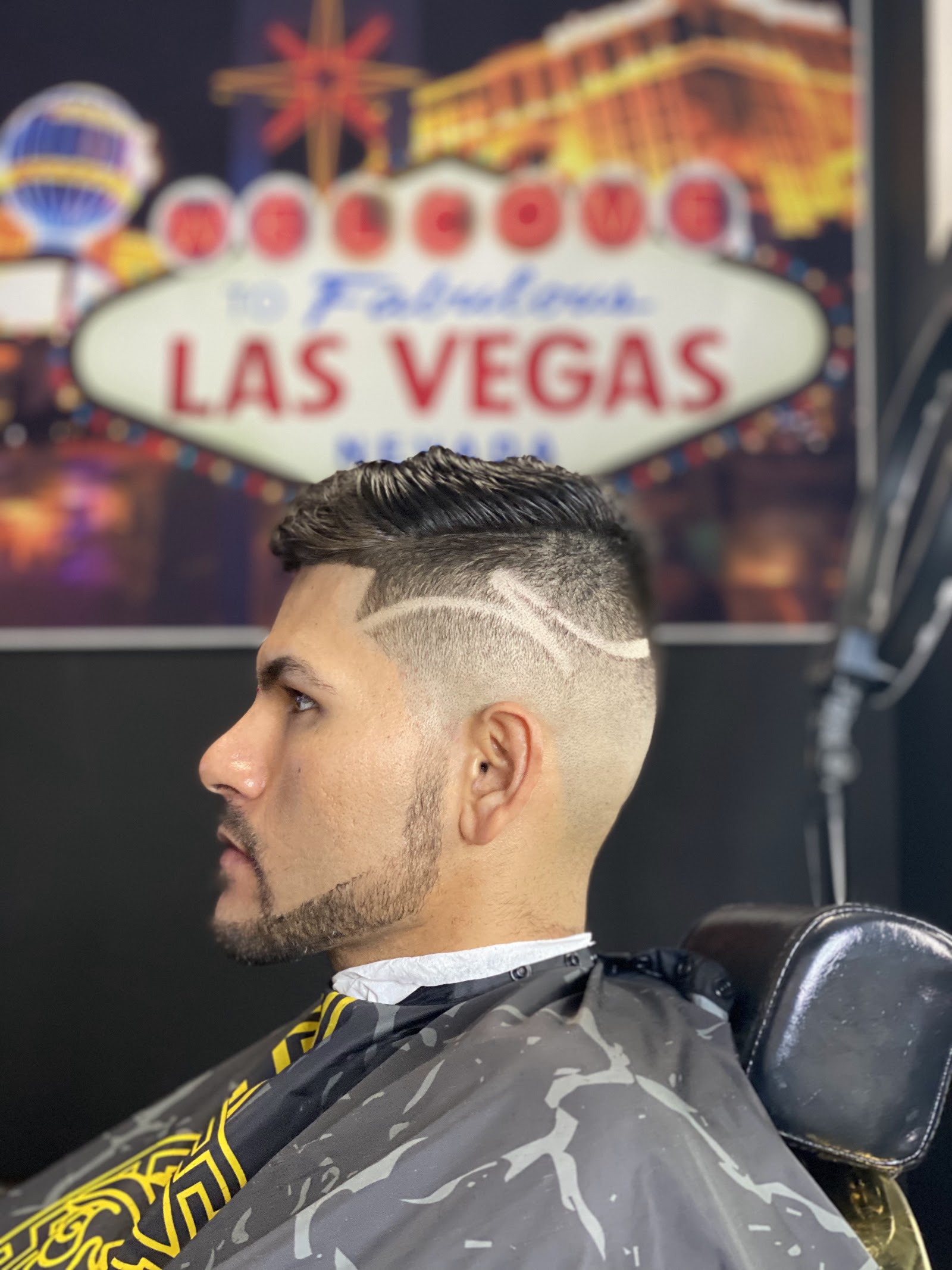 Side profile of a client with a clean fade and a hairline design line detail